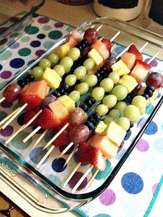 fruit skewers sitting on top of a glass tray