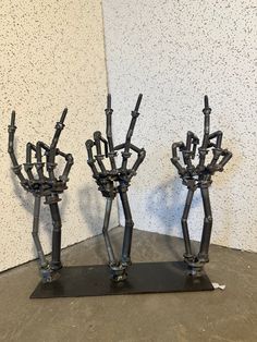 two metal sculptures made to look like hands holding each other's arms and legs