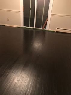 an empty room with hard wood flooring and sliding glass doors leading to the front door