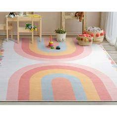 a child's play room with toys and rugs in pastel colors on the floor