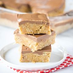 three pieces of peanut butter fudge bars stacked on top of each other with one bite taken out