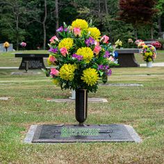 flowers are placed in a black vase on the headstones of those people who have fallen