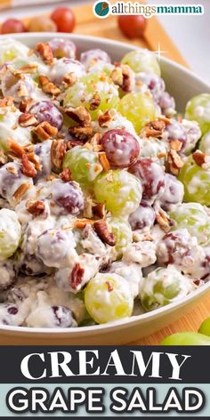 a bowl filled with grapes and nuts on top of a table