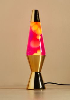 a colorful lamp sitting on top of a table next to a white wall and floor