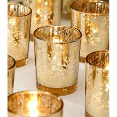 gold colored candles are lined up on a table