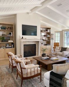 a living room filled with furniture and a flat screen tv mounted on the wall above a fireplace