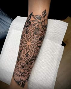 a woman's arm with a flower tattoo on it