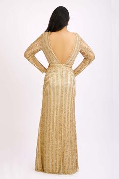 Beige-gold gown highlighted with vertical striped sequin embroidery, plunging V-neckline, sheer sleeves and low neck back.
Components:1
Embroidered
Neckline:V-Neck
Sleeve Length:Full
Color:Gold
Concealed zip closure at the back - Aza Fashions Gold V-neck Sequin Dress For Formal Occasions, Gold Embellished Sequin V-neck Dress, Gold Embellished V-neck Sequin Dress, Gold Sequined Long Sleeve Gown, Gold Long Sleeve Sequined Gown, Glamorous Gold Long Sleeve Gown, Glamorous Long Sleeve Gold Gown, Gold Long Sleeve Sequin Prom Dress, Gold Sequined V-neck Gown