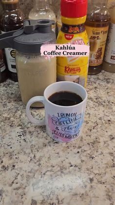 a cup of coffee sitting on top of a counter next to some condiments