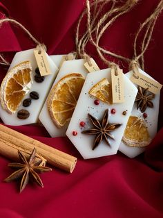 three orange slices with cinnamon and star anise on them