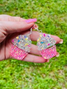 These beautiful sparkly earrings are hand-crafted by me from resin.  These earrings are very light-weight. Great for summer or your favorite baker/cupcake lover! Due to the nature of resin crafting, there may be some slight variation in color & designs.  Please see pictures for hook/post type. Instagram: @vgbjewelry Pinterest:  https://www.pinterest.com/vgbjewelry/ Facebook:  https://www.facebook.com/voodoogypsybeach/ TikTok: shellpeterson1 *Be sure to "like" us on FB, follow us on Instagram and Handmade Resin Jewelry In Sweet Style, Sweet Handmade Resin Jewelry, Handmade Sweet Resin Jewelry, Sparkly Cupcakes, Resin Crafting, Sparkly Earrings, Resin Earrings, Jewelry Earrings Dangle, Cupcake