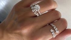 a woman's hand with three diamond rings on top of her ring and the middle finger