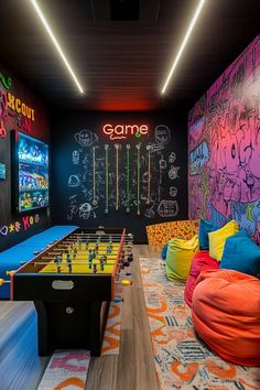 an indoor game room with bean bag chairs and neon colored walls, chalk writing on the wall