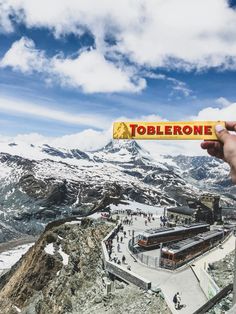 a person holding up a piece of paper with the word toblerone on it