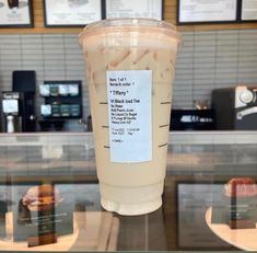 a plastic cup sitting on top of a counter next to a display case filled with drinks