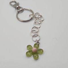 a keychain with a flower on it sitting on top of a white table