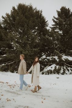 two people walking in the snow holding hands