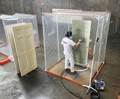 two men in white work on an enclosure