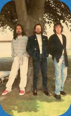 three men standing next to each other under a tree