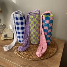 three crocheted vases sitting on top of a wicker basket