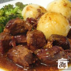 some meat and potatoes on a plate with broccoli