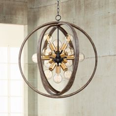 a chandelier hanging from the ceiling in a room with concrete walls and windows