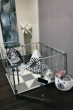 a glass display case sitting on top of a wooden floor next to a white vase