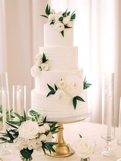 a wedding cake with white flowers and greenery