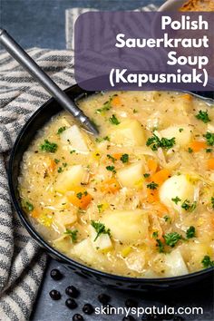 a bowl of soup with potatoes and carrots next to a loaf of bread on a table