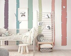 a child's bedroom decorated in pastel colors with trees painted on the wall