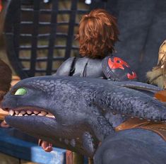 an animated character is riding on the back of a large dinosaur in a scene from dreamworks's how to train your dragon