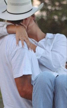 a man in a white hat is hugging a woman