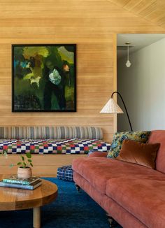 a living room with two couches and a coffee table in front of a painting on the wall