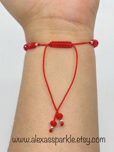 This beautifully handmade bracelet is made of medium (4mm) red crystal rondelle beads, small silver colored beads with a silver St. Benedict charm in the middle and a flat evil eye glass bead. The bracelet is made with thread string with a sliding knot to adjust to the majority of the wrist sizes. These are a great accessory for everyday wear. This bracelet is beautifully made and is also great for spiritual protection purposes. The purpose of using the Saint Benedict medal is to call on God's b Red Spiritual Beaded Bracelets With Sliding Knot, Red Spiritual Bracelet With Adjustable Length, Elegant Adjustable Red Rosary Bracelet, Adjustable Red Rosary Bracelet, Adjustable Red Evil Eye Bracelet Hand-strung, Rose Bracelet, Saint Benedict, Spiritual Protection, Thread Bracelets