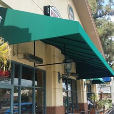 the outside of a restaurant with green awnings