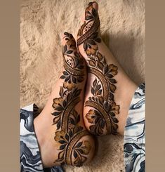 the legs and feet of a woman with henna tattoos