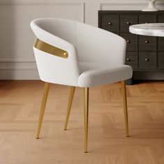 a white chair sitting on top of a hard wood floor next to a wooden table