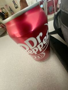 a red cup sitting on top of a table next to a person's backpack