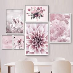 a dining room table with white chairs and pictures on the wall above it, including pink flowers