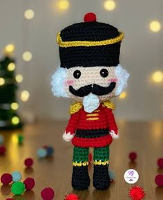 a crocheted nutcracker is standing in front of a christmas tree