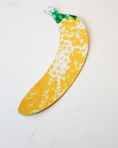 a banana painted yellow and green with white spots