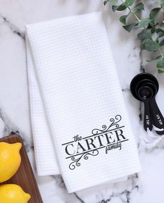 two white towels sitting on top of a counter next to lemons