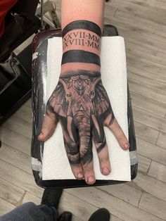 a hand with an elephant tattoo on it and the words evil - m & m written on it