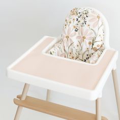 a baby's highchair with a flower print seat cover sitting on top of it