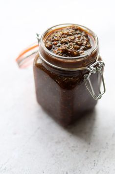 a jar filled with brown sauce sitting on top of a table