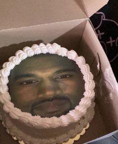 the man is looking at the cake in the box