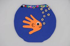 an orange fish in a blue bowl with beads around it