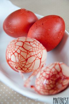 three pieces of red fruit sitting on top of a white plate next to each other