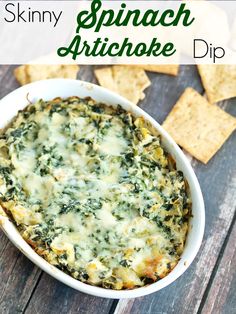 spinach artichoke dip in a white bowl with crackers on the side