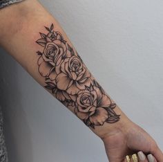 a black and white rose tattoo on the arm